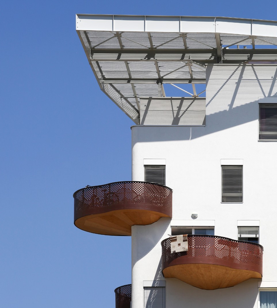 Façade d'un immeuble d'habitation moderne avec balcons arrondis, illustrant l'expertise de HABIGED dans le secteur de l'immobilier social